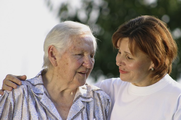 Pflegerin begleitet ältere Dame fürsorglich